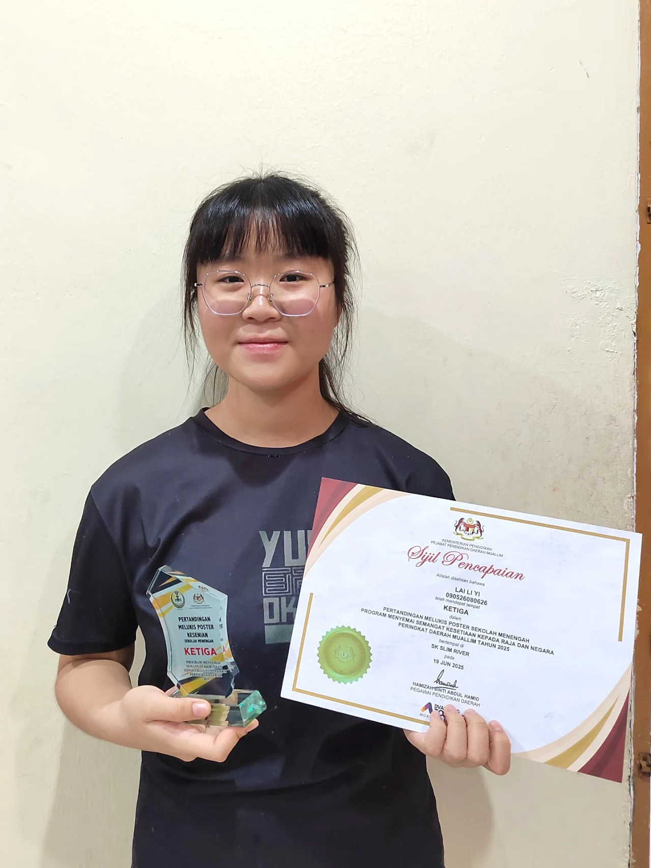 Student holding an art achievement certificate