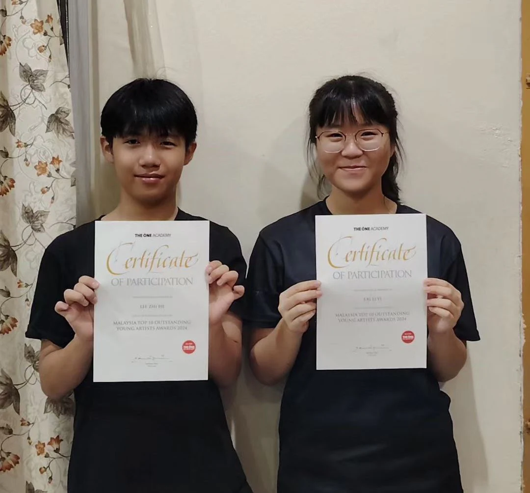 Two students holding achievement certificates