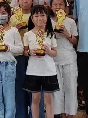 Young artists standing together with trophies after an award ceremony