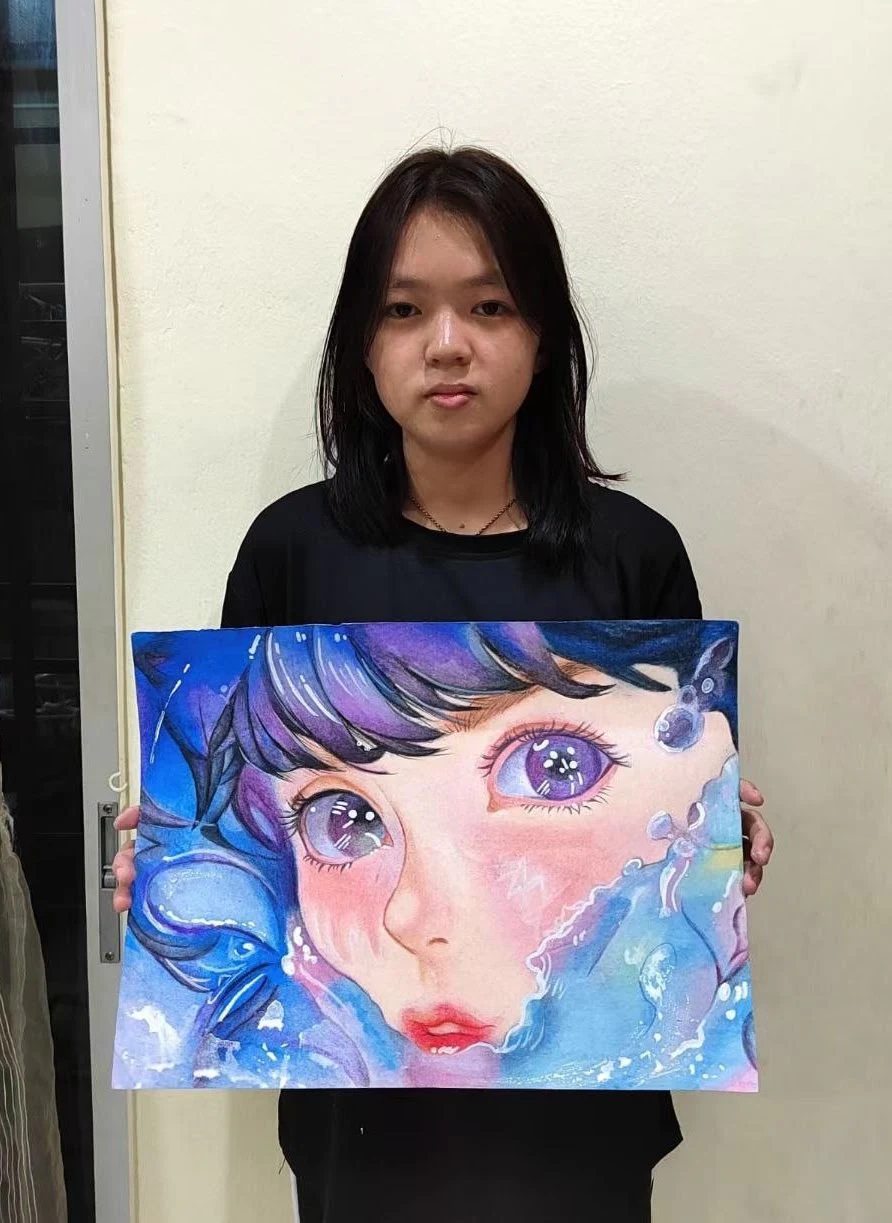 Student holding an expressive blue-haired portrait