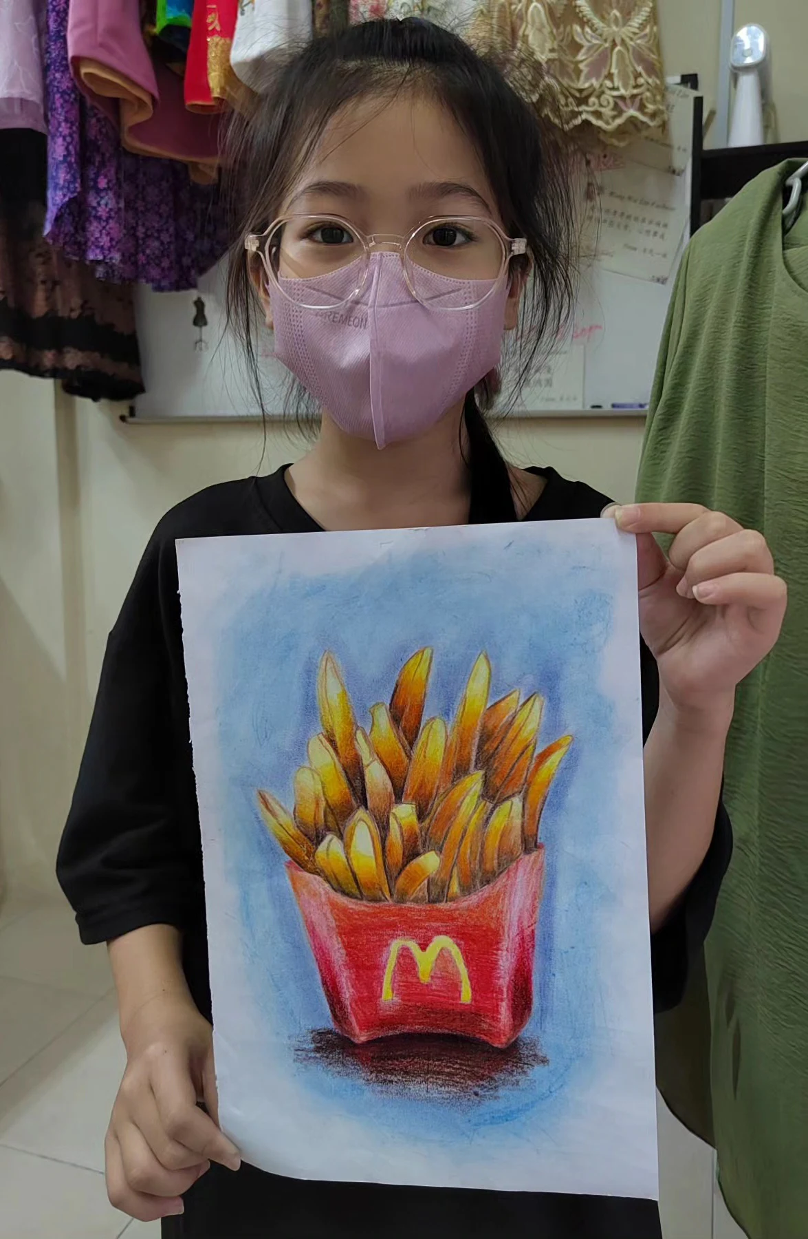 Student holding a colourful packet of fries drawing
