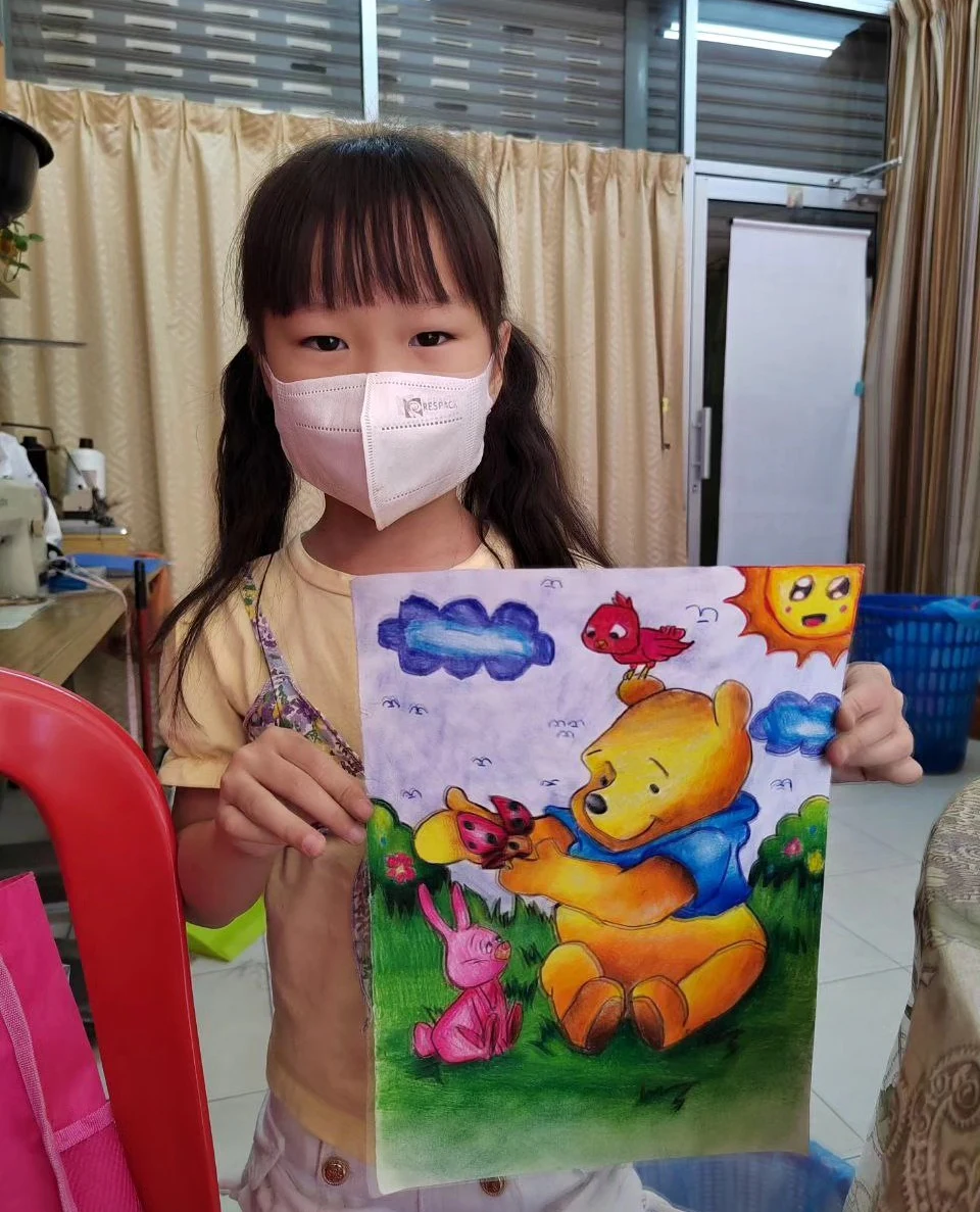 Student holding a cheerful forest character scene